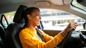 Happy young african american woman driving her car and smiling