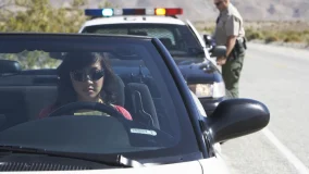 Women sitting in convertible car appearing calm after being pulled over by police
