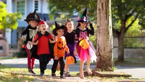 Child trick or treating on suburban street being safe and having fun