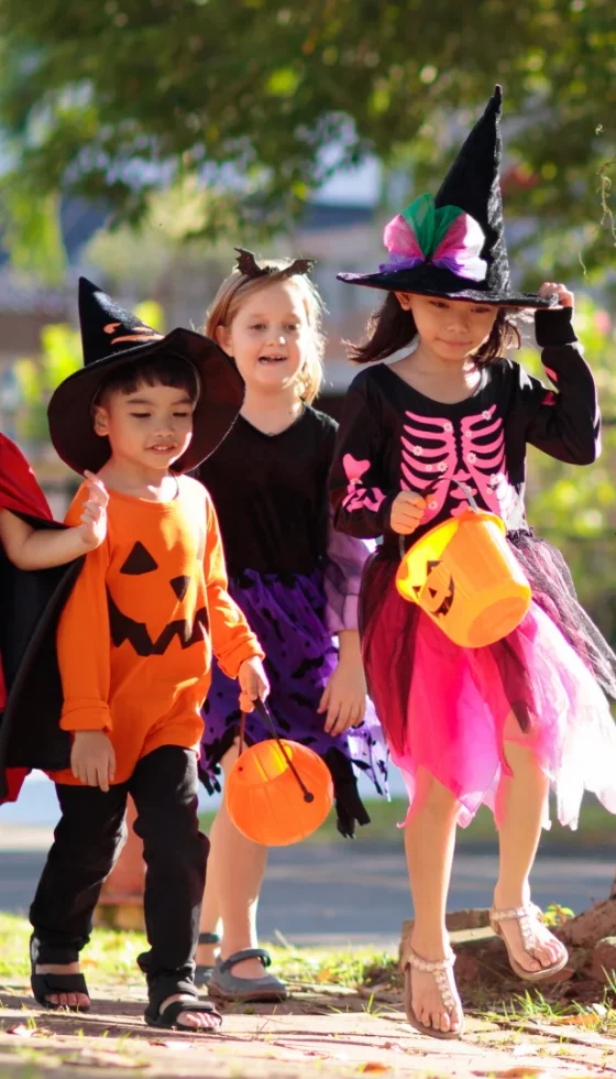 Child trick or treating on suburban street being safe and having fun