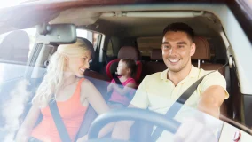 happy man and woman with little child driving in car without distractions