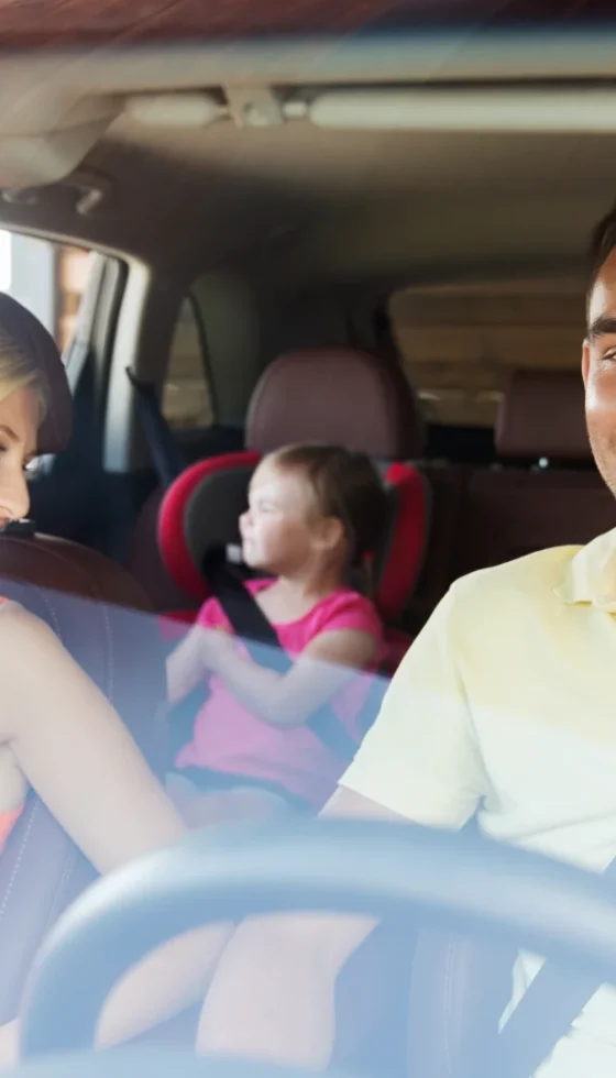 happy man and woman with little child driving in car without distractions