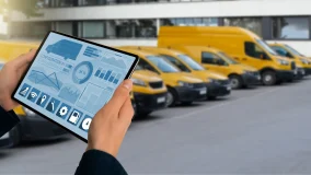 Manager with a digital tablet on the background of fleet of commercial vehicles
