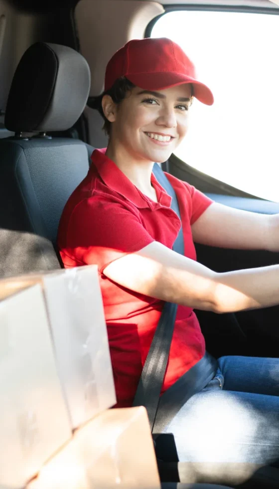 Commercial delivery woman driving behind the wheel and starting to make package deliveries in her van