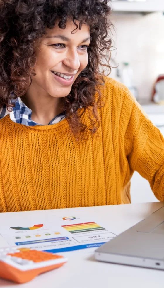 Cheerful woman comparing online website credit score and paper insurance policy statement