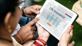 Family reviewing laptop computer with life insurance message displayed on the screen.