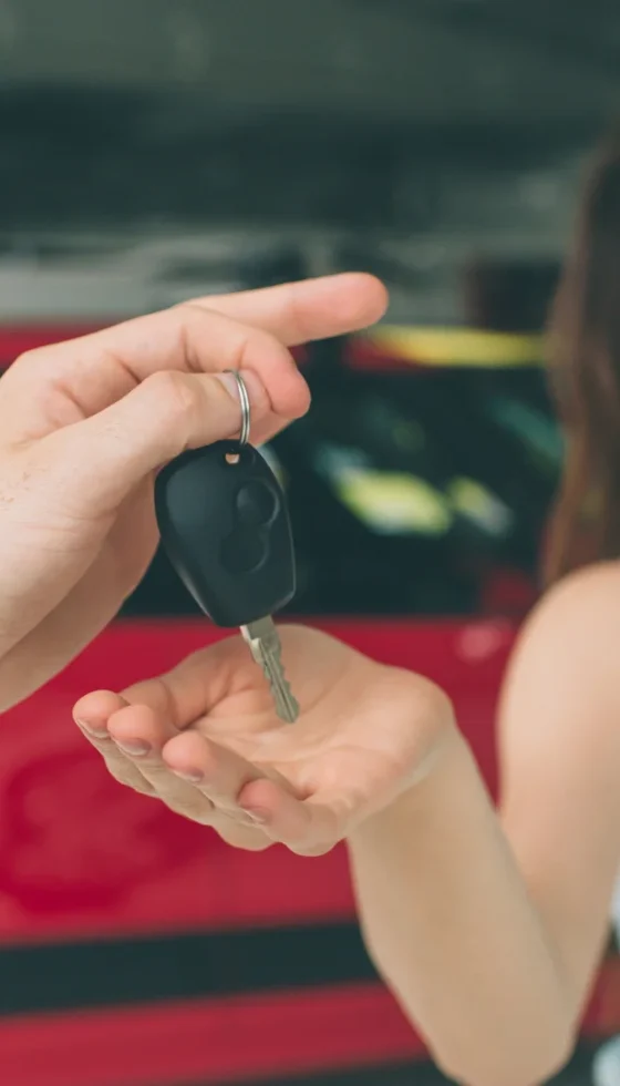 Young happy woman being handed a keyfob to her new car at a dealership