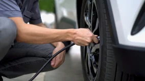 Man filling air in the tires of his car for safety and regular maintenance