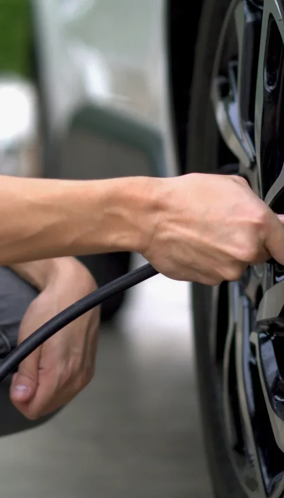 Man filling air in the tires of his car for safety and regular maintenance