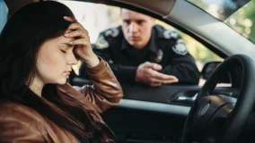 Male cop in uniform stopped female driver and hand holding her forehead in frustration