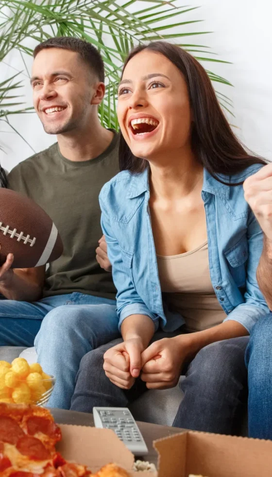 Group of friends hosting a football watching party on TV.