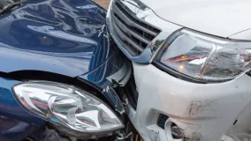 Silver and blue cars crashed front bumpers accident on the road