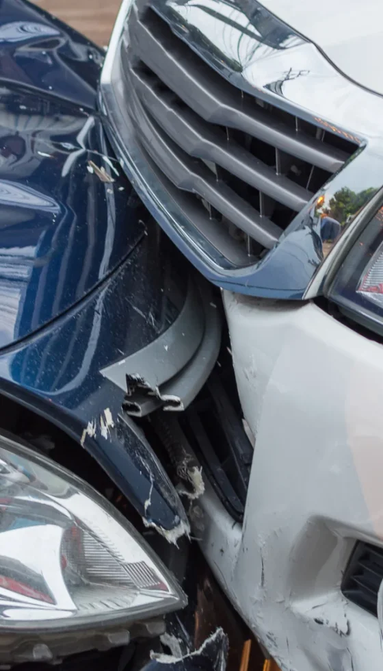 Silver and blue cars crashed front bumpers accident on the road