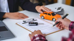 Insurance agent reviewing auto insurance policy coverage documents and set of car keys