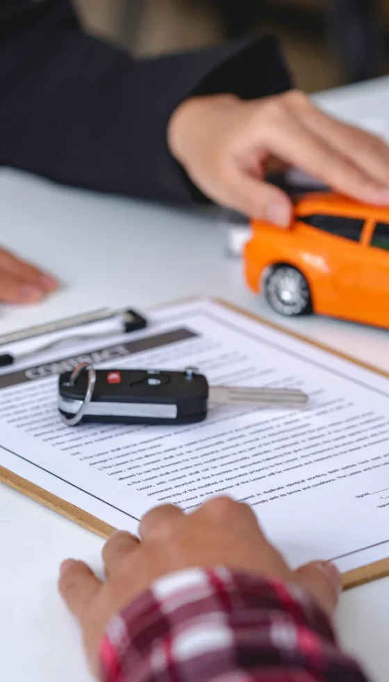 Insurance agent reviewing auto insurance policy coverage documents and set of car keys