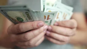 close-up of man counting cash with both hands.