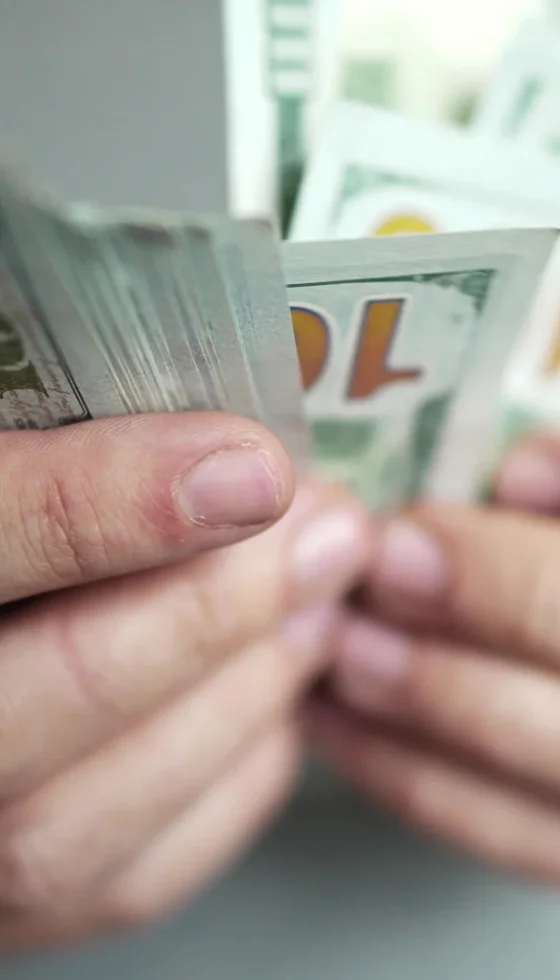 close-up of man counting cash with both hands.