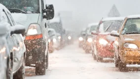 Car traffic jam on busy highway caused by heavy snowfall and cold weather