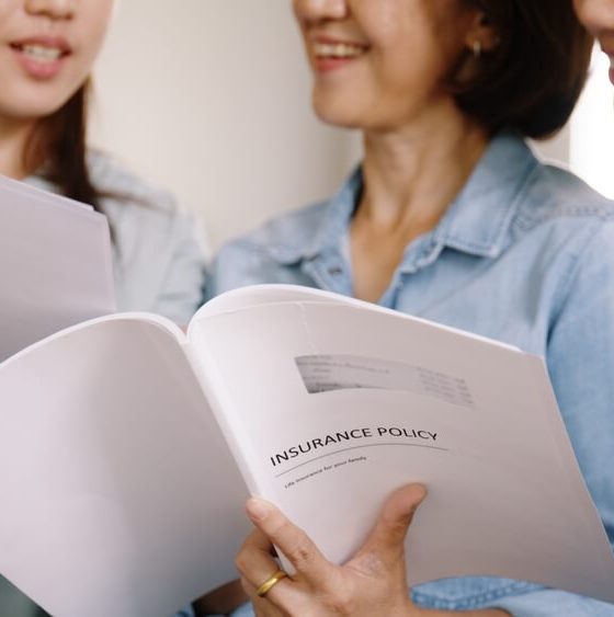 Group of women examine their home insurance policy - cheap homeowners insurance.