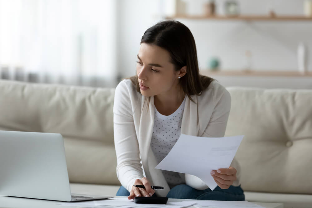 Young woman scrutinizes her insurance policy - cheap homeowners insurance.