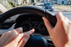 Woman's fingers pointing at the odometer of her vehicle to check the mileage - Acceptance, cheap auto insurance