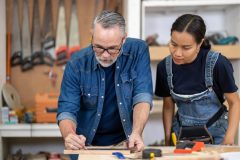 Woman and man carpenters in a woodwork shop - Acceptance, cheap business insurance