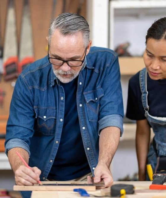Woman and man carpenters in a woodwork shop - Acceptance, cheap business insurance