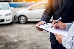 Insurance adjuster next to the driver after a car accident - Acceptance, cheap auto insurance