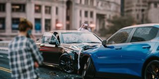 Two men look at the collision their cars have just had.