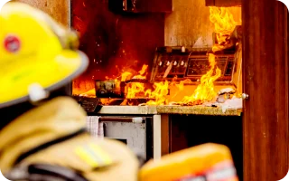 fireman viewing kitchen stove and counter on fire and owner is covered by homeowners insurance