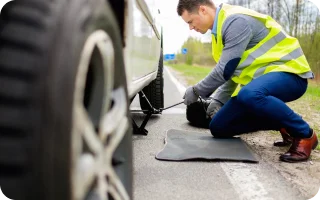 Roadside assistance man changing a flat car tire