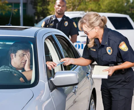 Man driving a car being pulled over by female police officer