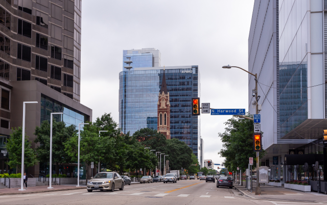 View of a downtown street in Dallas, Texas, showing cars and pedestrians at a traffic stop in front of a traffic light – Dallas, cheap car insurance in Texas